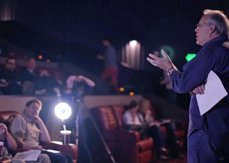 man speaking to crowd in movie theatre
