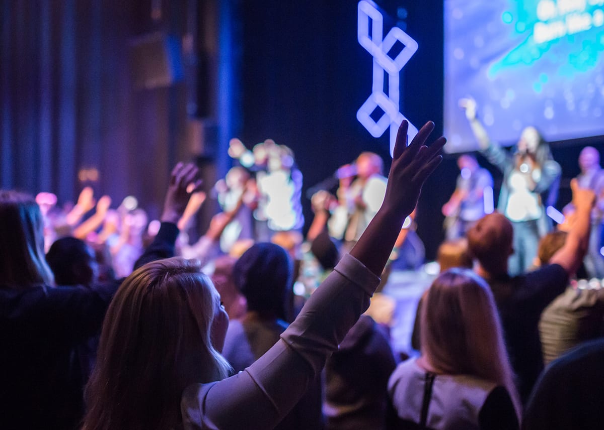 woman holding hand up at church service
